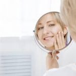 A woman checking her teeth in the mirror